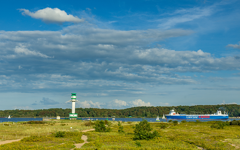 Blick auf den Kieler Leuchtturm und ein Frachtschiff