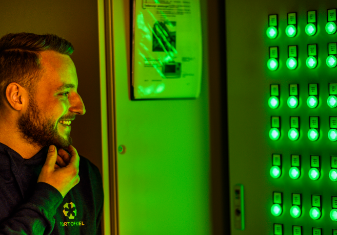 Employee of the IT department stands in front of the control cabinet.