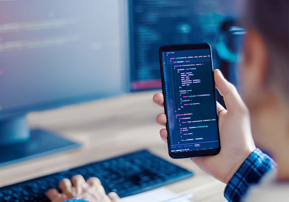 Symbolic image of person looking at cell phone with source code