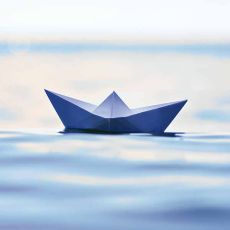 Symbolic image of paper ship on water