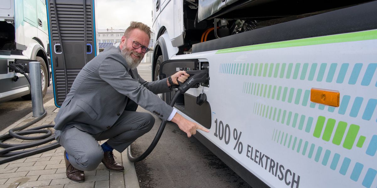 Claus Ruhe Madsen, Minister für Wirtschaft, Verkehr, Arbeit, Technologie und Tourismus des Landes Schleswig-Holstein, demonstriert, wie ENGIE Vianeo am PORT OF KIEL schwere Nutzfahrzeuge mit erneuerbarer Energie versorgt.