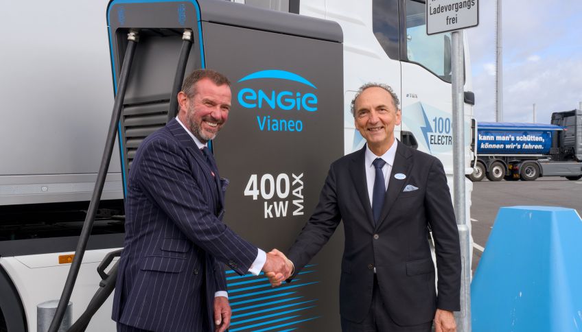 Frank Lacroix, ENGIE (rechts), und Dr. Dirk Claus, SEEHAFEN KIEL GmbH & Co. KG, schütteln sich die Hand vor einer E-Ladesäule.